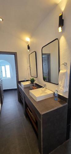 a bathroom with two sinks and a large mirror at Hotel Finca Campo Bello in Cerro Verde
