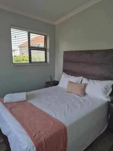 a bedroom with a large white bed with a window at Holland Manor in Durban