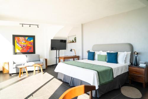 una camera d'albergo con un grande letto con cuscini blu di Hotel Finca Campo Bello a Cerro Verde