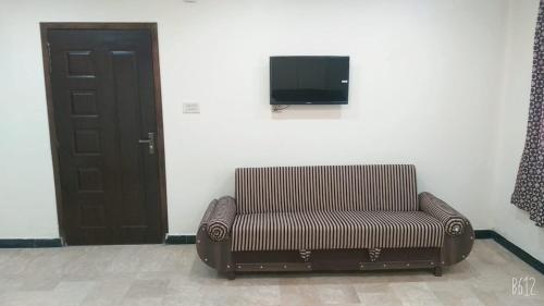 una silla sentada en una habitación con TV en la pared en All khair guest house Murree, en Murree