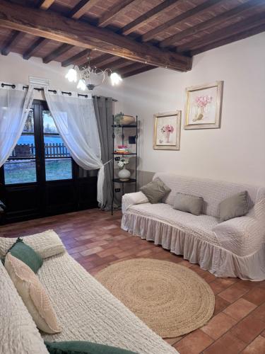 a living room with two couches and a large window at Locazione turistica ex Le Casette Di Cedromonte in Panicale