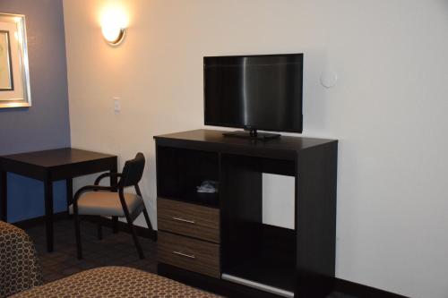 una habitación de hotel con TV de pantalla plana en una cómoda en Hawthorn Suites by Wyndham Columbia en Columbia