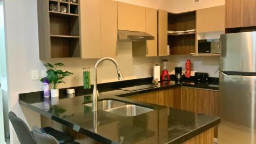a kitchen with a sink and a refrigerator at Estilo Minimalista frente Arena y Parque Fundidora in Monterrey