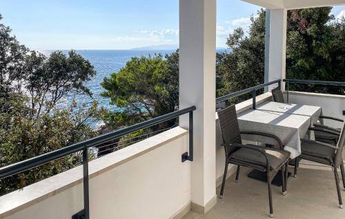 a balcony with a table and chairs and the ocean at Cozy Apartment In Dingac With Outdoor Swimming Pool in Gornji Dingač