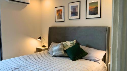 um quarto com uma cama com uma almofada verde em Estilo Minimalista frente Arena y Parque Fundidora em Monterrey