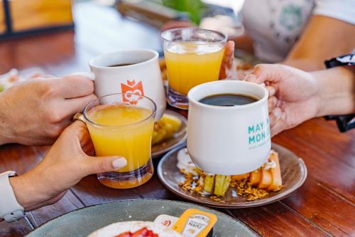 a group of people sitting at a table with coffee and breakfast at Mayan Monkey Los Cabos - Social Hotel in Cabo San Lucas