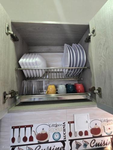 a small refrigerator with plates and utensils on shelves at Luxury five in Villavicencio