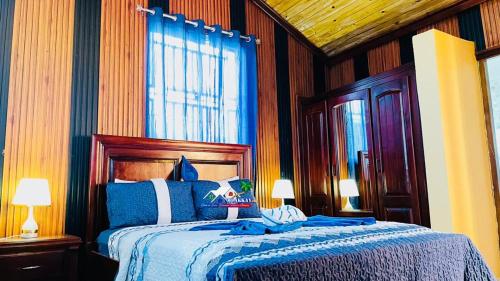 a bedroom with a bed with a blue comforter at Belo Résidence in Cap-Haïtien
