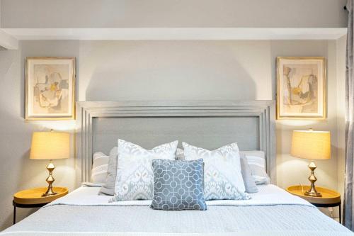 una camera da letto con un letto con cuscini e due lampade di Downtown Seattle Corner Unit with Skyline Views a Seattle