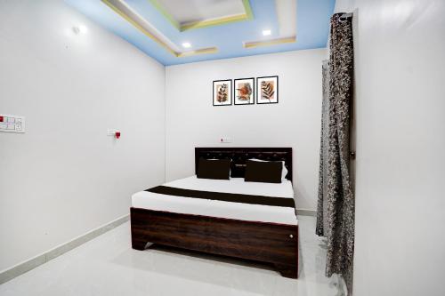 Un dormitorio con una cama en una habitación blanca. en HOTEL O MAYUR, en Aligarh