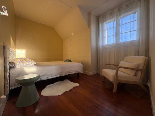 una camera da letto con un letto, una sedia e una finestra di Hildegarde's Friend a Brienne-le-Château