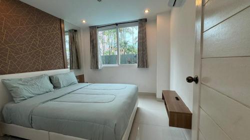 a bedroom with a bed and a window and a door at Amazon Condo, Building B, ground floor with direct pool access in Jomtien Beach