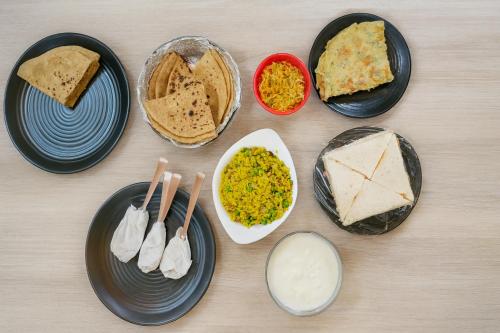 uma mesa com pratos e tigelas de diferentes tipos de alimentos em The Aura by Backpackers Stop em Nainital