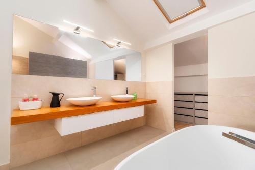 baño con 2 lavabos en una encimera de madera en Casa De Mariposas Viola, en Faro