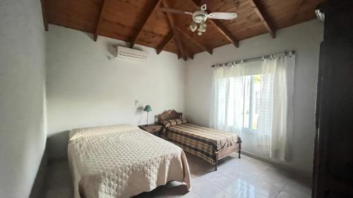 een slaapkamer met een bed en een plafondventilator bij Casa Quinta Metac-Calle Entre Rios y Sarmiento in Villa Lía