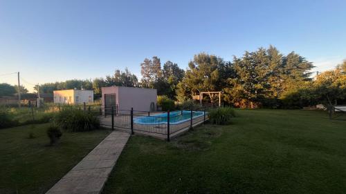 een achtertuin met een zwembad en een speeltuin bij Casa Quinta Metac-Calle Entre Rios y Sarmiento in Villa Lía