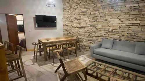 een woonkamer met een bank, een tafel en stoelen bij Black Hills Caviahue in Caviahue