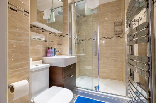 a bathroom with a shower and a toilet and a sink at Shenley House- Premium Stay, Private Parking for multiple cars, Sleeps 6, 2 Bedroom, 2 Ensuites, Central MK in Milton Keynes