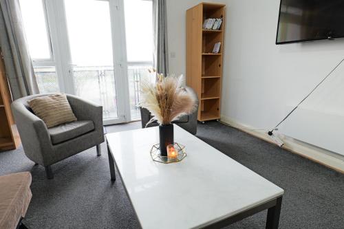 a living room with a table and a chair at City Center Base Spacious Apartment with Secure Parking in Manchester