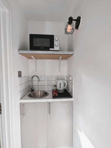 a small kitchen with a sink and a microwave at Lakeside Oxford Hotel in Oxford