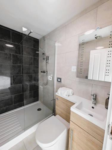 a bathroom with a toilet and a sink and a shower at Lakeside Oxford Hotel in Oxford