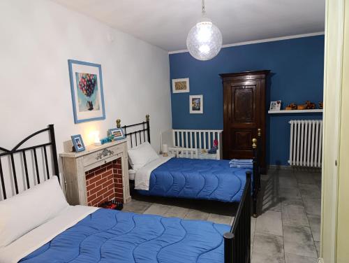two beds in a bedroom with blue walls at Casa Lilly in San Paolo Solbrito