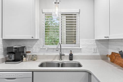 a white kitchen with a sink and a window at 2017 Marsh Walk Villa in Summerville