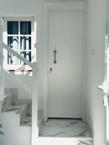 a white door in a white room with stairs at VV Abrante in La Restinga