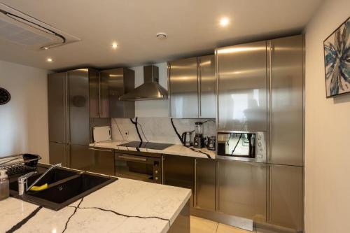 eine Küche mit Edelstahlschränken und einer Arbeitsplatte in der Unterkunft KAYs APARTMENT in Accra