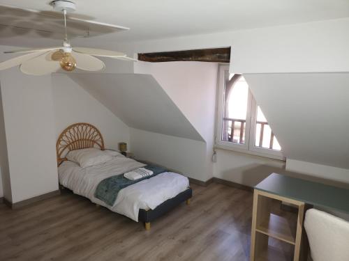 a bedroom with a bed and a ceiling fan at L'instant Doubs in Baume-les-Dames