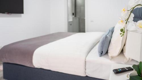 a bedroom with a white bed and a television at Sea La Vie in Mangalia