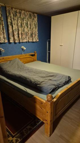 Bett in einem Zimmer mit Holzrahmen in der Unterkunft The Blue house apartment in Andøya