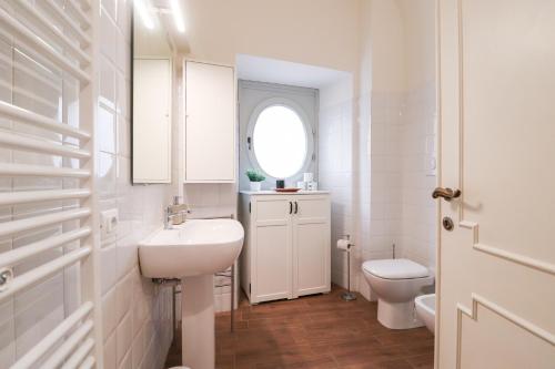 Un baño blanco con lavabo e inodoro. en Dragonetti Luxury House, en LʼAquila