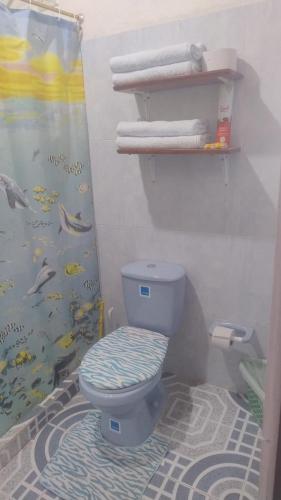 a bathroom with a blue toilet and some towels at Cabaña El Refugio in Duitama