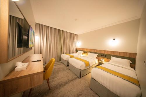 a hotel room with two beds and a television at HDN Hotel فندق هدن in Mecca