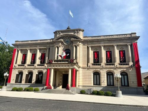 un gran edificio blanco con una bandera encima en Departamento a media cuadra de la plaza principal, en Tandil