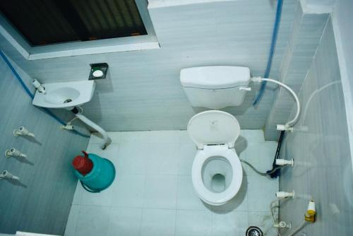 a small bathroom with a toilet and a sink at Radha Krishna Paying Guest House in Ayodhya