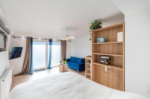 ein Schlafzimmer mit einem Bett und einer blauen Couch in der Unterkunft Appartement Poisy calme et résidentielle parking gratuit in Poisy