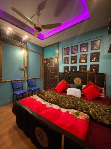 a bedroom with two beds and a purple ceiling at Cottage Inn in Faisalabad