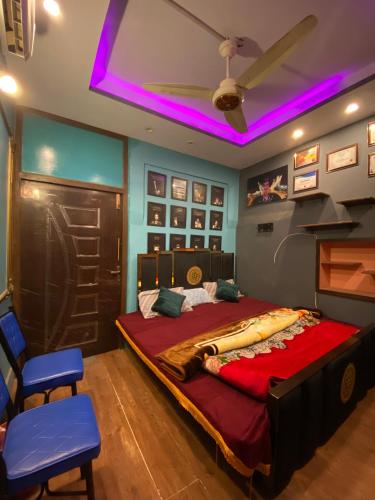 a bedroom with a large bed with a purple ceiling at Cottage Inn in Faisalabad