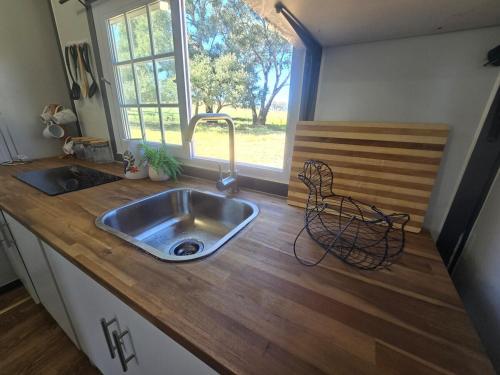 a kitchen counter with a sink and a window at The Country Nook in Manildra