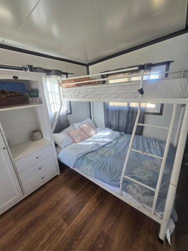 a bedroom with two bunk beds and a wooden floor at The Country Nook in Manildra