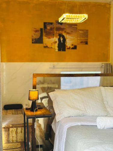 a bedroom with a bed and a table with a lamp at Pousada Quinta das cores in Urubici