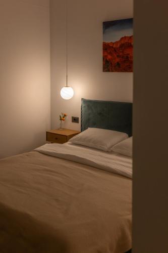 a bedroom with a bed and a pendant light at Urban Grove Apartment in Floreşti