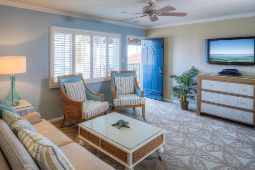 a living room with a couch and chairs and a tv at Scripps Inn in San Diego