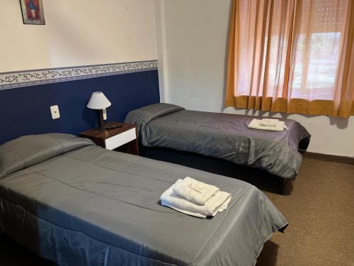 two beds in a hotel room with towels on them at 3Reyes in Necochea