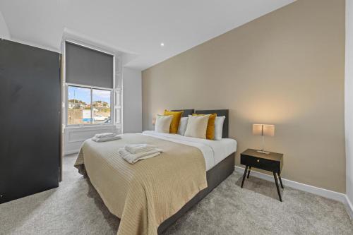a bedroom with a large bed and a window at The Manor - Beachwalk Apartments in Ayr