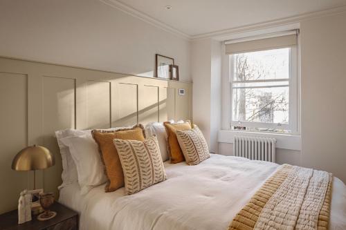 a bedroom with a large white bed with pillows at Chic Georgian Escape near Royal Crescent in Bath