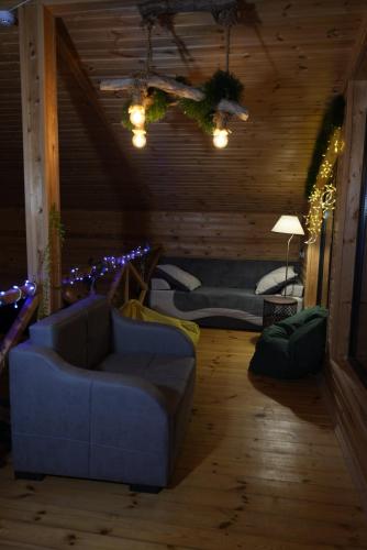 a living room with a blue couch and lights at Wooden Villa Sormoni in Tskaltubo