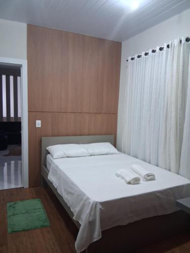 a bedroom with a bed with two towels on it at Apartamento moderno próximo ao centro in União da Vitória